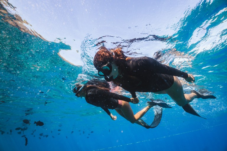 two girls snorkeling with fins