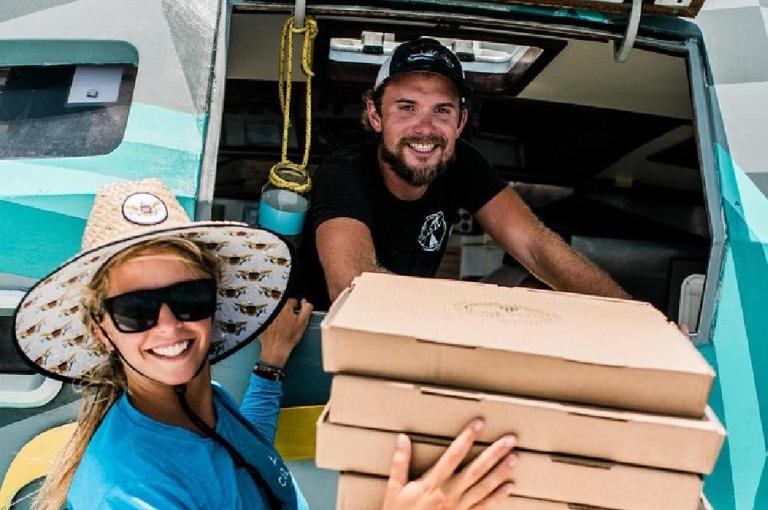 staff carrying boxes of pizza pi