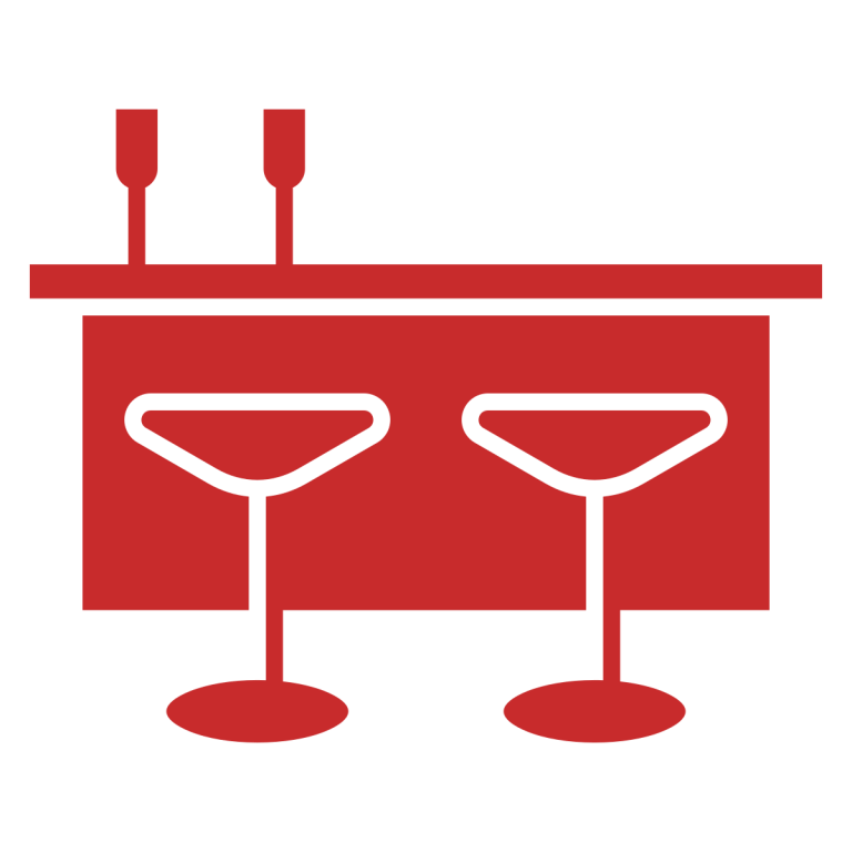 Red icon of a bar counter with two stools and two glasses on top.