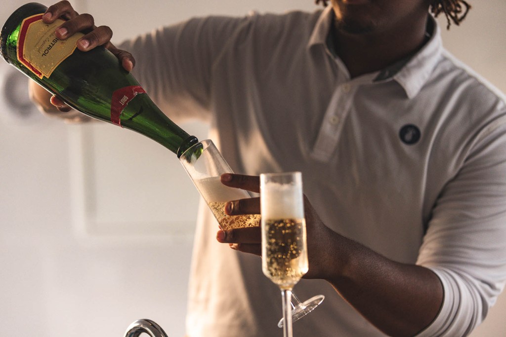 Person pouring champagne into a glass.