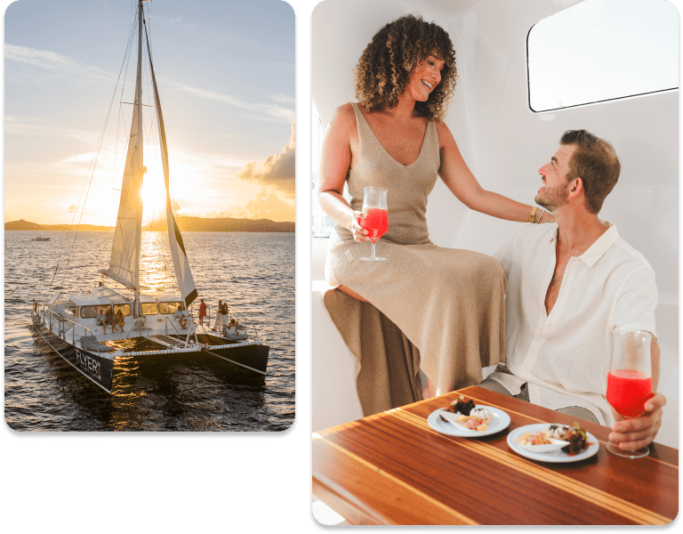 Couple enjoying drinks on a yacht, with a sailboat at sunset in the background.